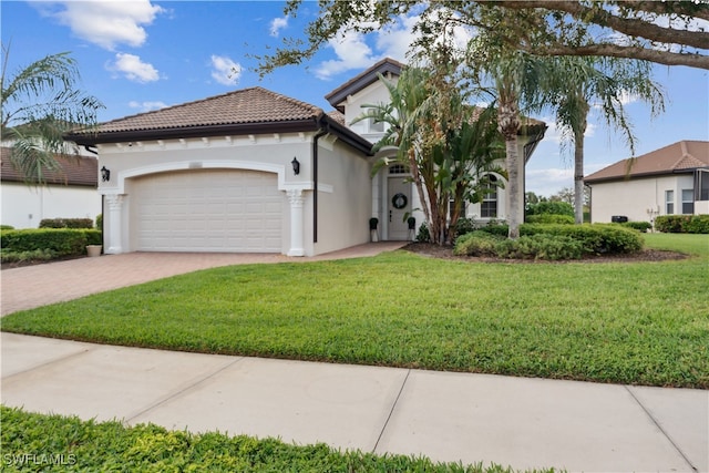 mediterranean / spanish house with a garage and a front lawn