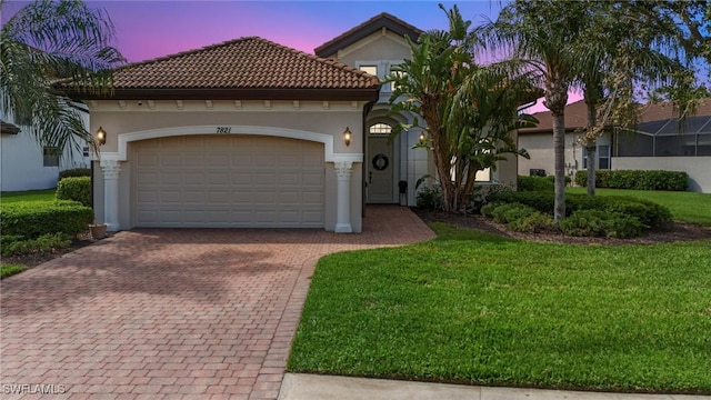 mediterranean / spanish house with a lawn and a garage