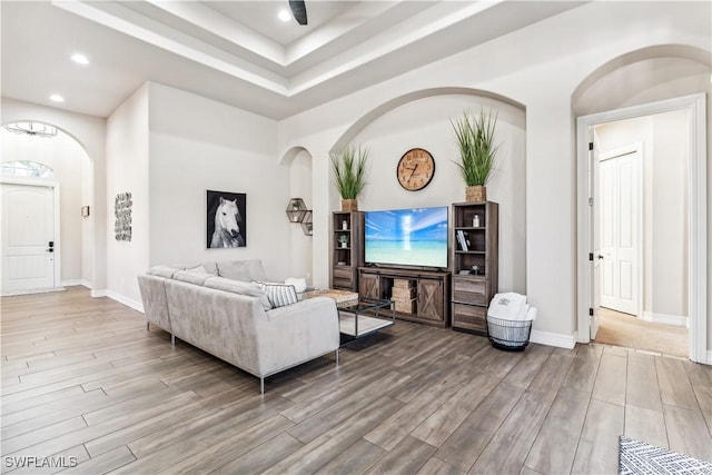 7821 Ashton Rd, Naples, FL 34113 - living room with wood finished floors, arched walkways, recessed lighting, and a tray ceiling