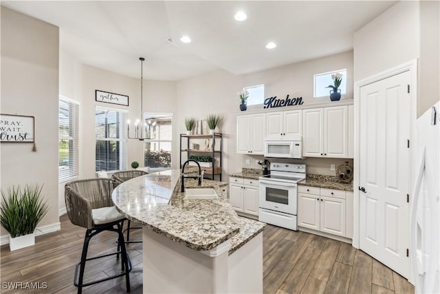 kitchen featuring white cabinets, white appliances, plenty of natural light, and sink