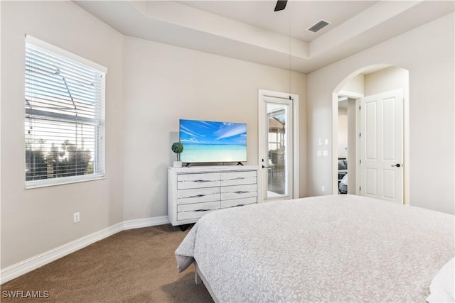 carpeted bedroom with a raised ceiling, ceiling fan, and access to outside