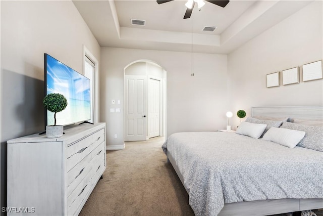 7821 Ashton Rd, Naples, FL 34113 - bedroom with a raised ceiling, light colored carpet, arched walkways, and a ceiling fan