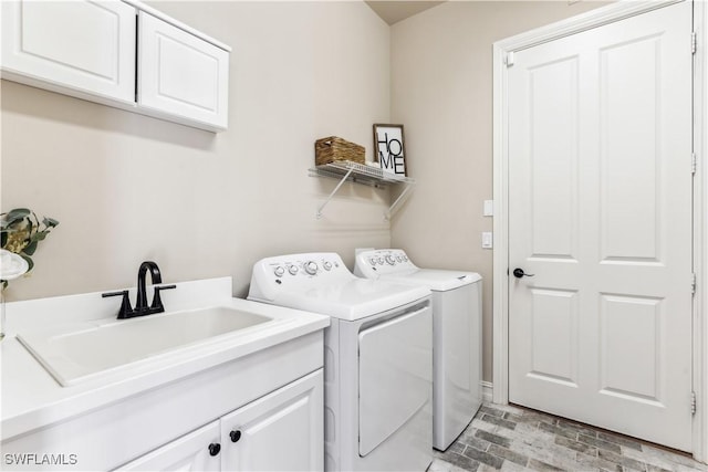 laundry room featuring cabinets, sink, and washing machine and clothes dryer