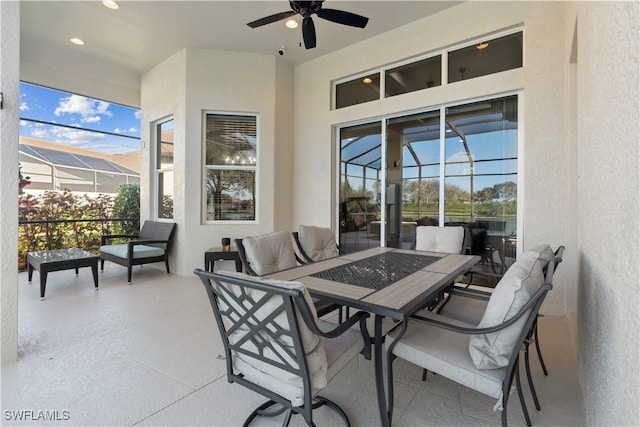 view of patio with glass enclosure and ceiling fan