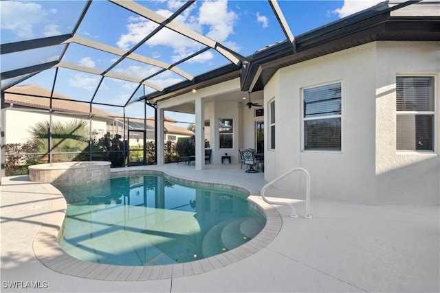 view of swimming pool with a patio area, ceiling fan, and glass enclosure