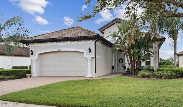 mediterranean / spanish-style house featuring a garage and a front lawn