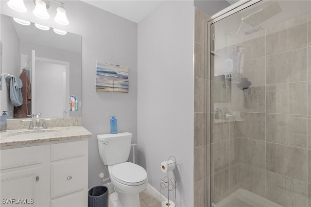 bathroom featuring toilet, vanity, an enclosed shower, and tile patterned flooring