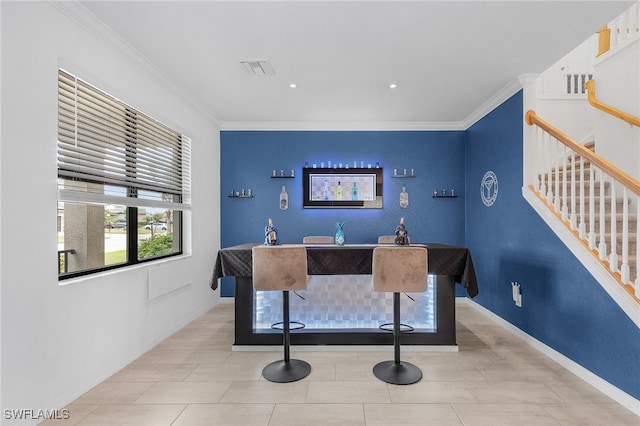 office with light tile patterned flooring, crown molding, and indoor bar