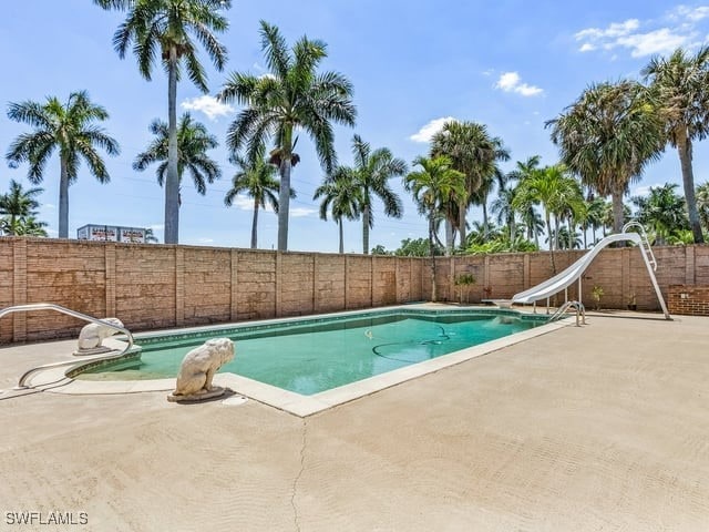 view of swimming pool featuring a patio and a water slide