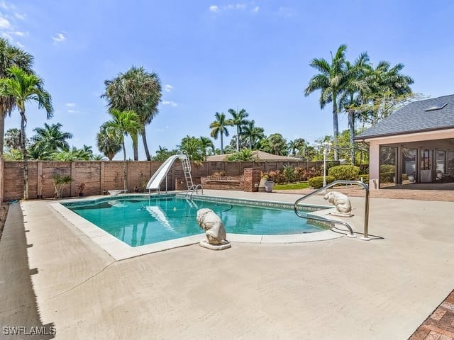 view of pool featuring a water slide and a patio area