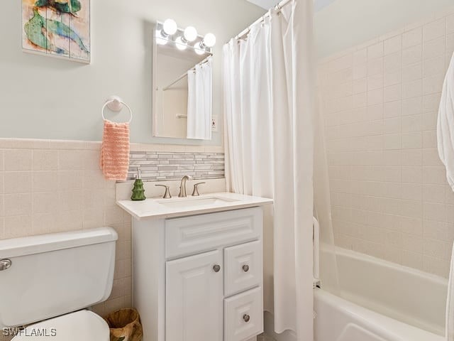 full bathroom featuring vanity, toilet, tile walls, and shower / tub combo