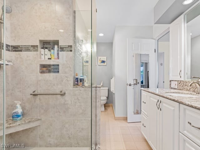 bathroom with vanity, toilet, tile patterned floors, and an enclosed shower