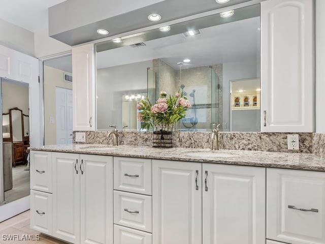 bathroom featuring vanity, walk in shower, and wood-type flooring