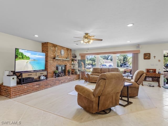 living room with ceiling fan, a fireplace, and light tile patterned floors