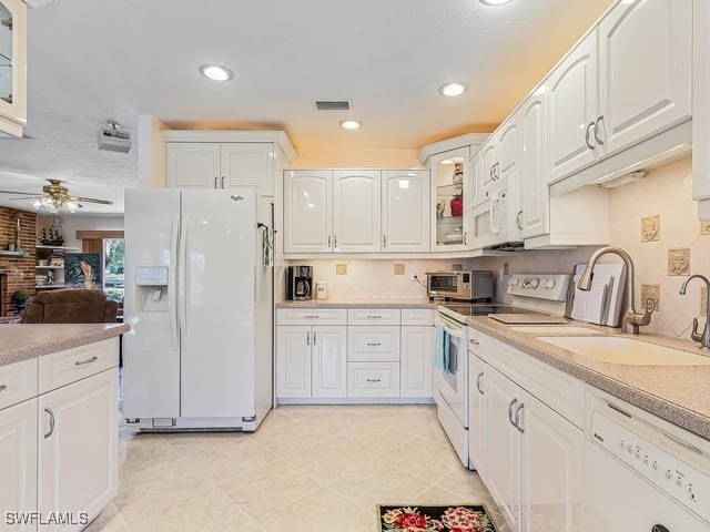 kitchen featuring sink, light tile patterned floors, white cabinetry, white appliances, and ceiling fan