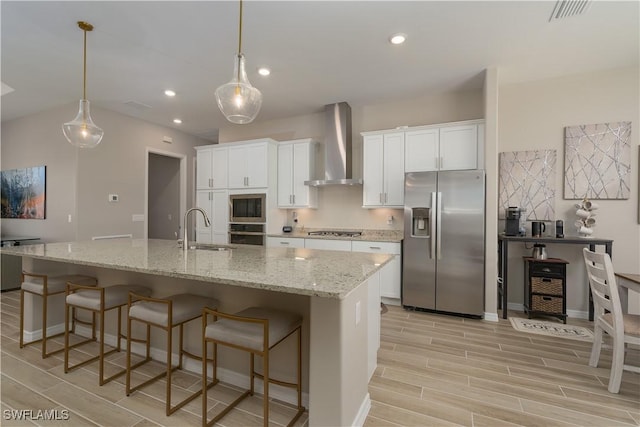 kitchen featuring a sink, white cabinets, wall chimney exhaust hood, and stainless steel appliances