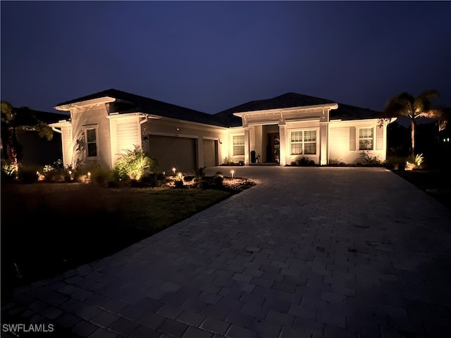 view of front of house featuring an attached garage and decorative driveway