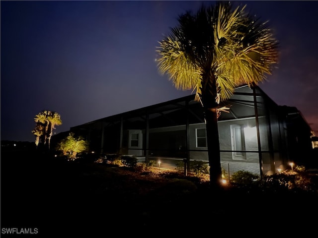 back of house at night with a lanai