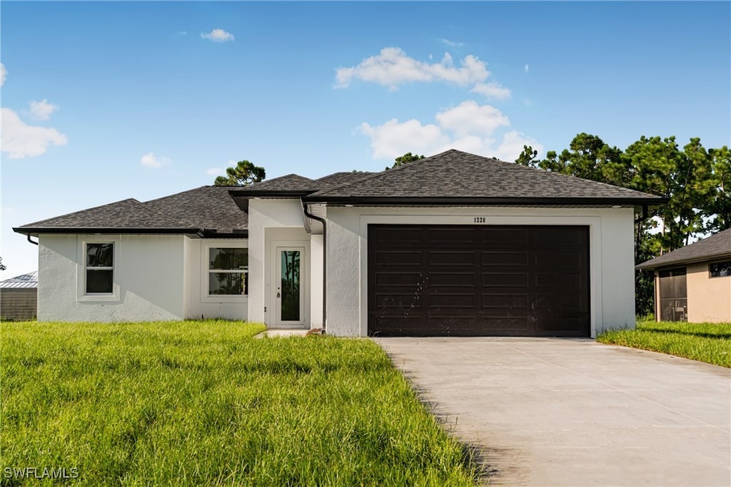 view of front of home featuring a front yard and a garage