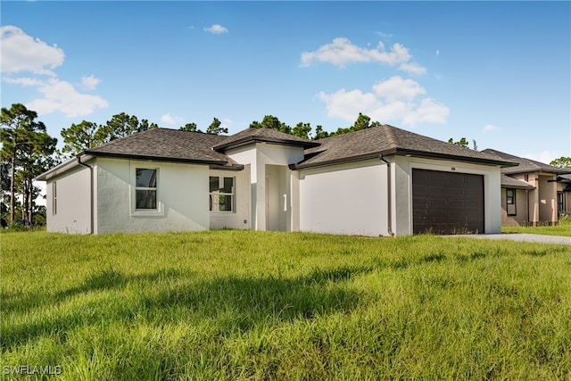 prairie-style home featuring a front lawn and a garage