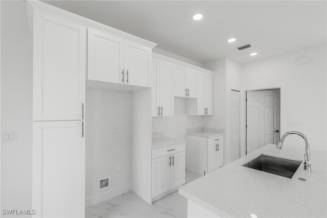 kitchen featuring sink and white cabinets