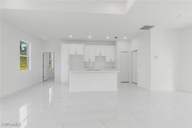 kitchen featuring white cabinetry, a kitchen island with sink, and sink