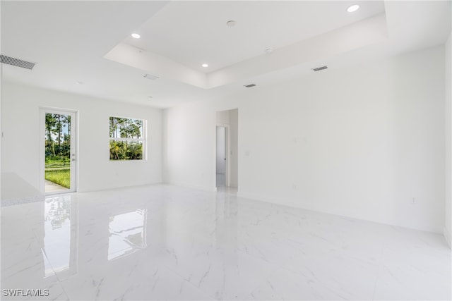 spare room with a raised ceiling