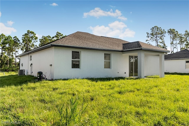 back of property featuring cooling unit and a yard