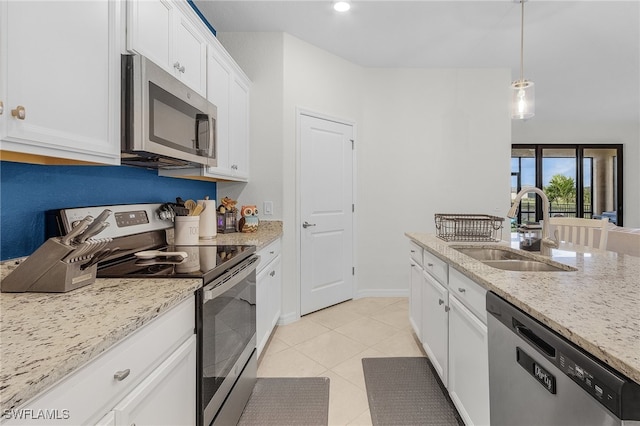 kitchen featuring white cabinetry, appliances with stainless steel finishes, pendant lighting, light stone countertops, and sink