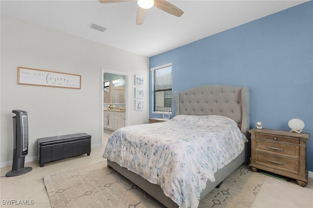 bedroom featuring light tile patterned floors, ceiling fan, and ensuite bath