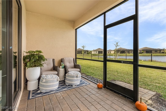 sunroom / solarium featuring a water view