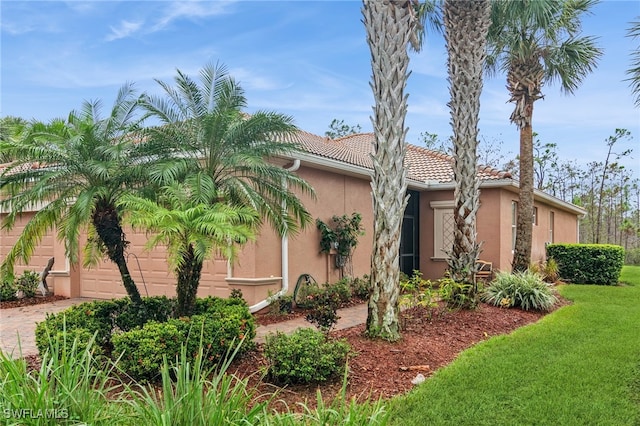 view of property exterior featuring a garage and a yard