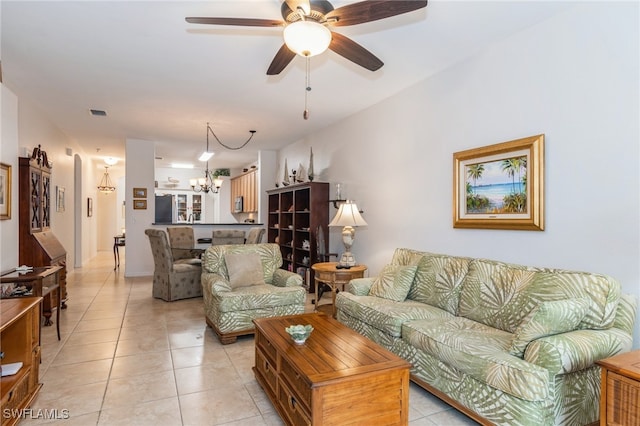 living room featuring ceiling fan with notable chandelier and light tile patterned floors