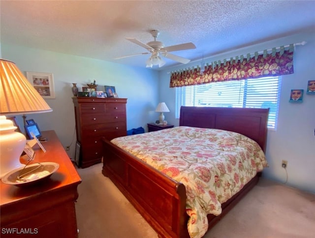 bedroom featuring light carpet, a textured ceiling, and ceiling fan