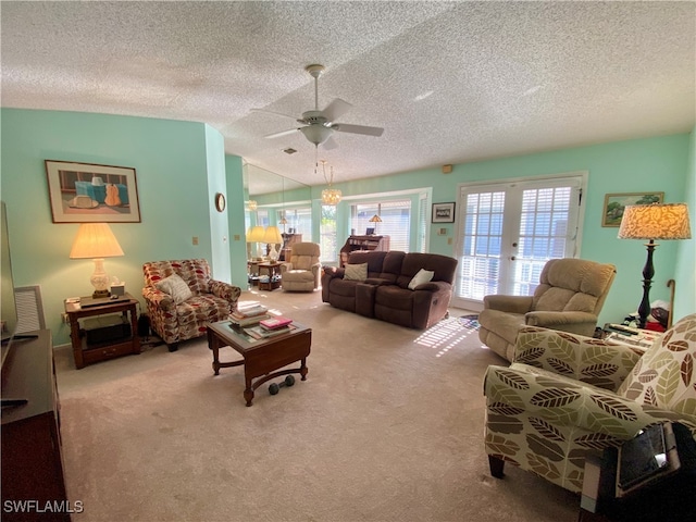 living room with lofted ceiling, ceiling fan, a textured ceiling, french doors, and light colored carpet