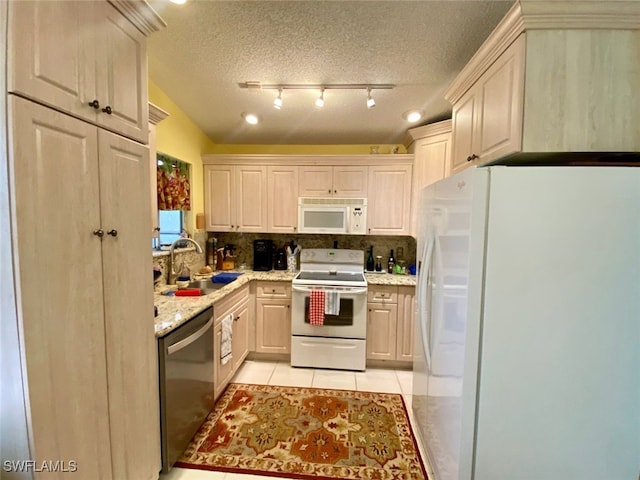 kitchen with white appliances, tasteful backsplash, sink, a textured ceiling, and light tile patterned floors