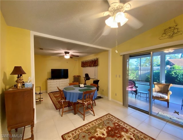 dining room with a textured ceiling, ceiling fan, light tile patterned flooring, and vaulted ceiling