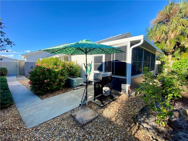 exterior space featuring central AC unit and a sunroom