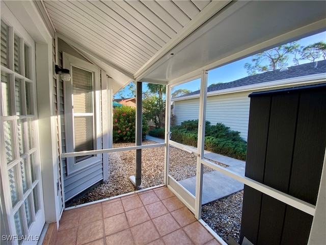 unfurnished sunroom featuring lofted ceiling and wooden ceiling