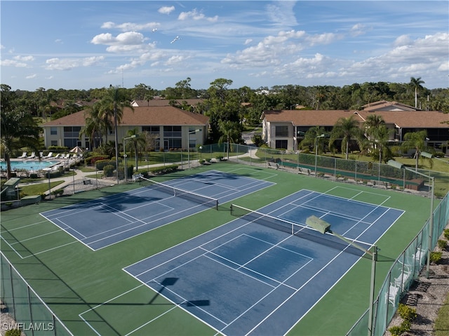 view of tennis court featuring a community pool