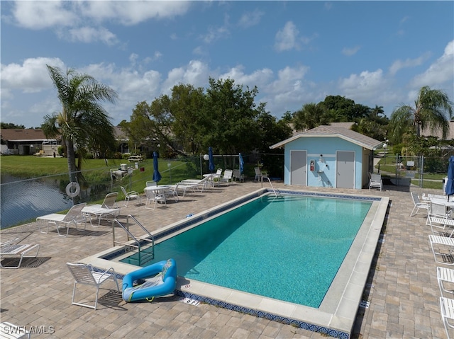 view of pool featuring a patio area and an outbuilding