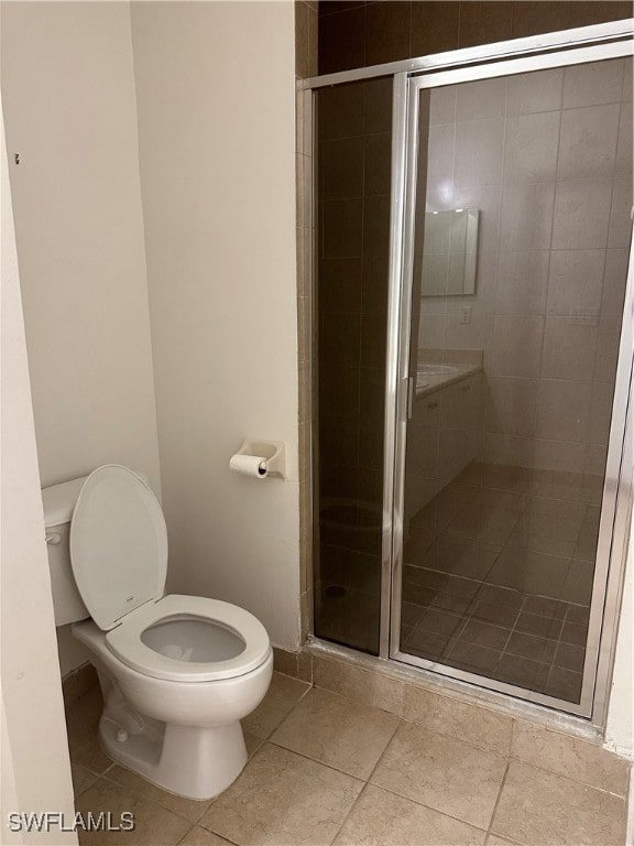 bathroom featuring toilet, tile patterned floors, and an enclosed shower