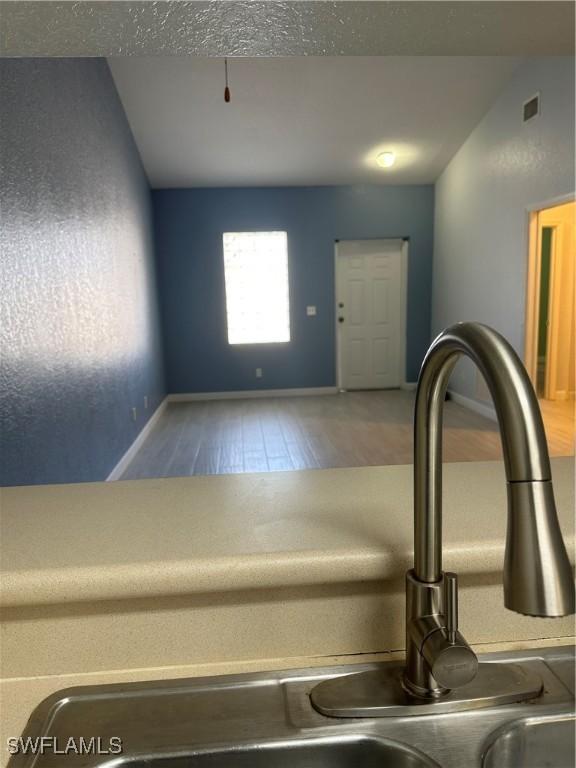 8358 Bernwood Cove Loop Unit 706, Fort Myers, FL 33966 - kitchen view of wood finished floors, a sink, and baseboards
