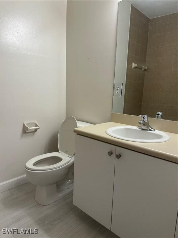 8358 Bernwood Cove Loop Unit 706, Fort Myers, FL 33966 - bathroom with vanity, toilet, baseboards, and wood finished floors