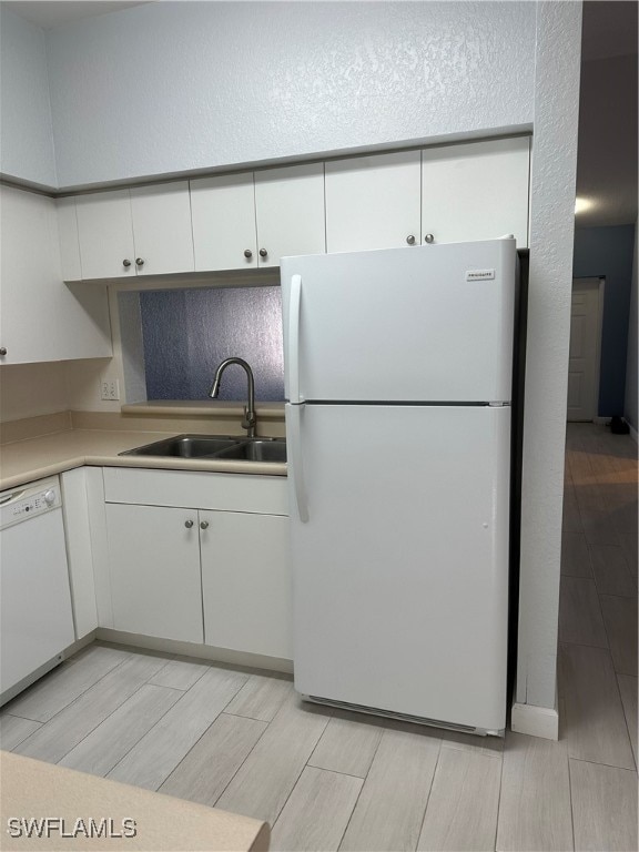 kitchen with white appliances, sink, and white cabinets