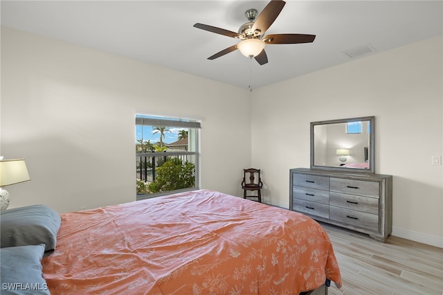 bedroom with a ceiling fan, visible vents, baseboards, and wood finished floors