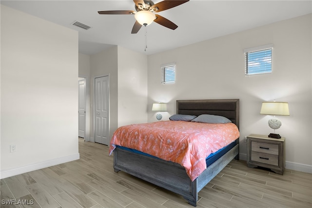 bedroom with a ceiling fan, baseboards, visible vents, a closet, and wood tiled floor