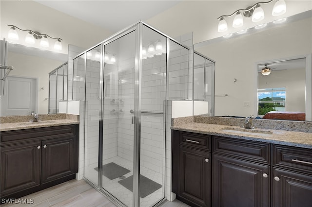 ensuite bathroom featuring a stall shower, two vanities, a sink, and ensuite bathroom