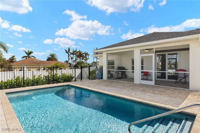 view of swimming pool featuring fence, a sunroom, grilling area, a fenced in pool, and a patio area