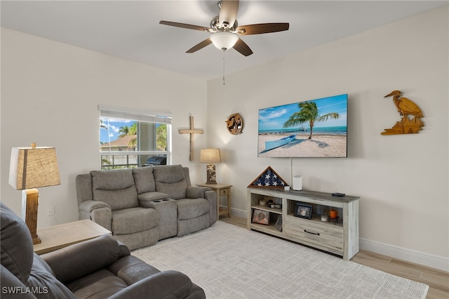 living room featuring wood finished floors, a ceiling fan, and baseboards